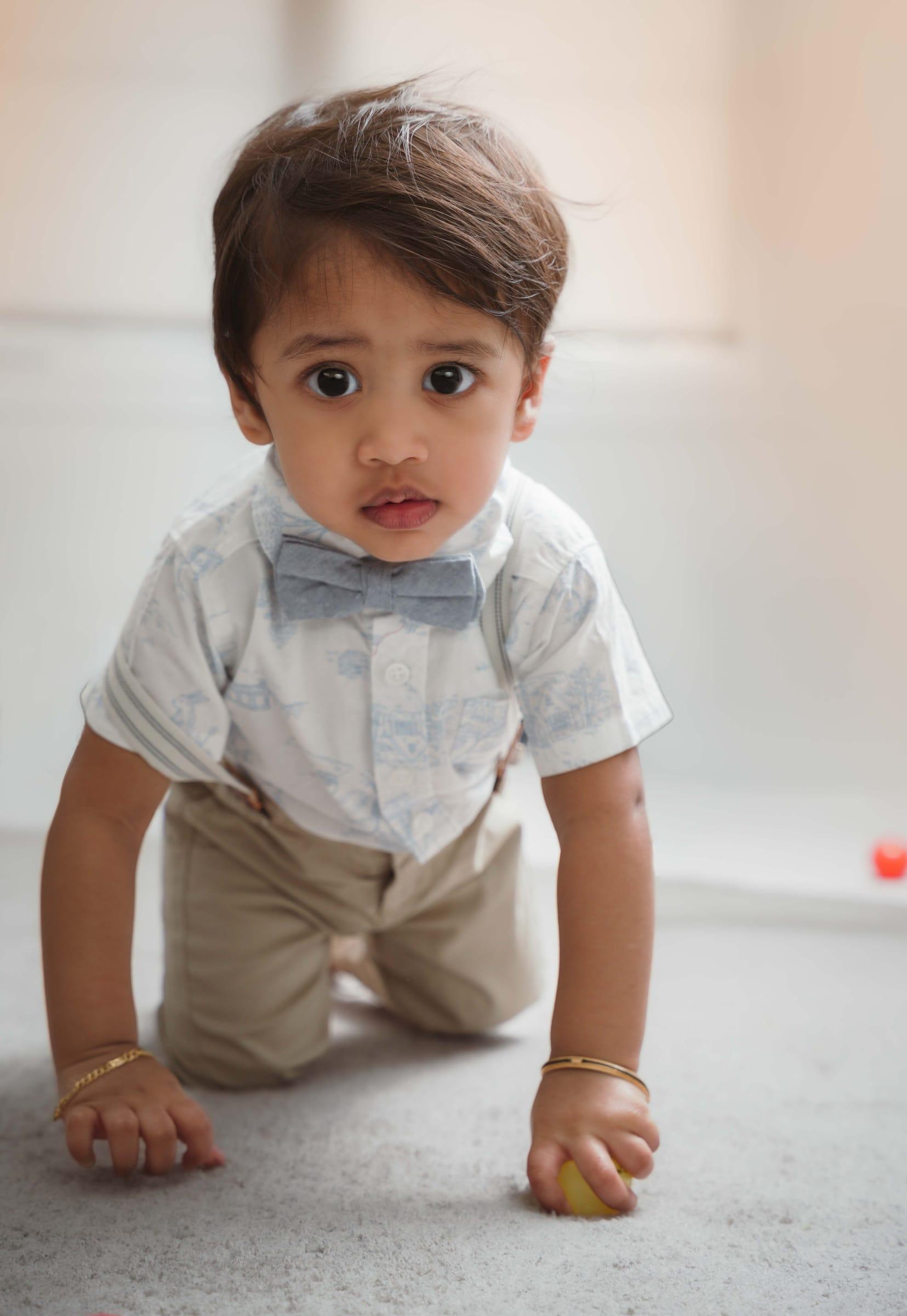 Toddler crawling in a bow tie during a first birthday photo session