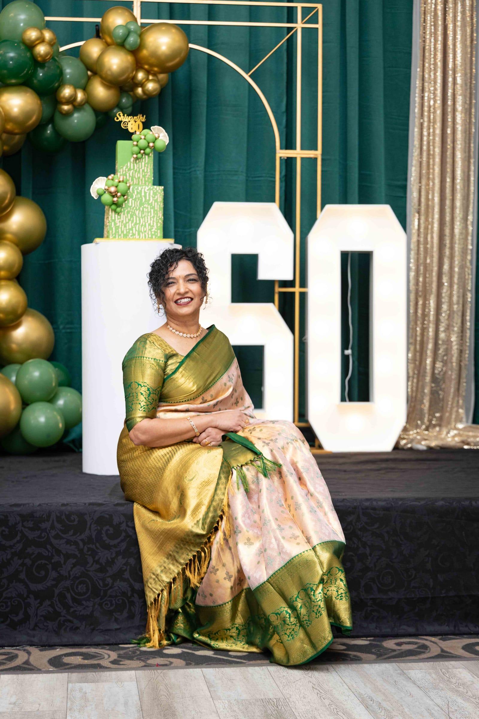 Woman celebrating her 60th birthday in a silk saree on stage