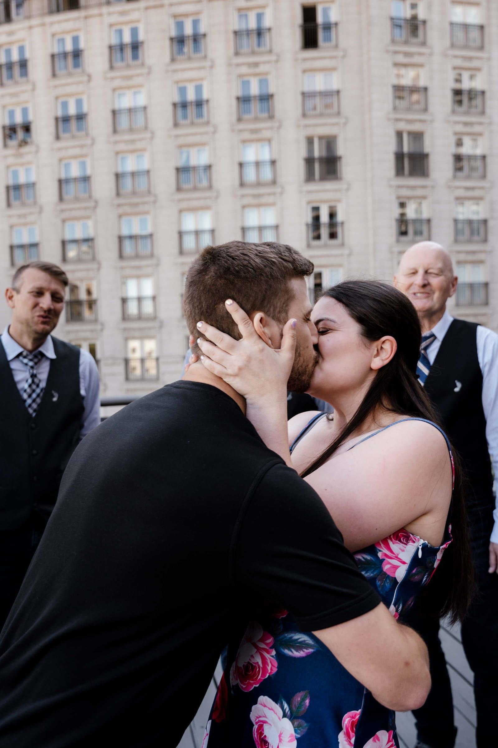Couple kisses moments after a rooftop marriage proposal in Toronto