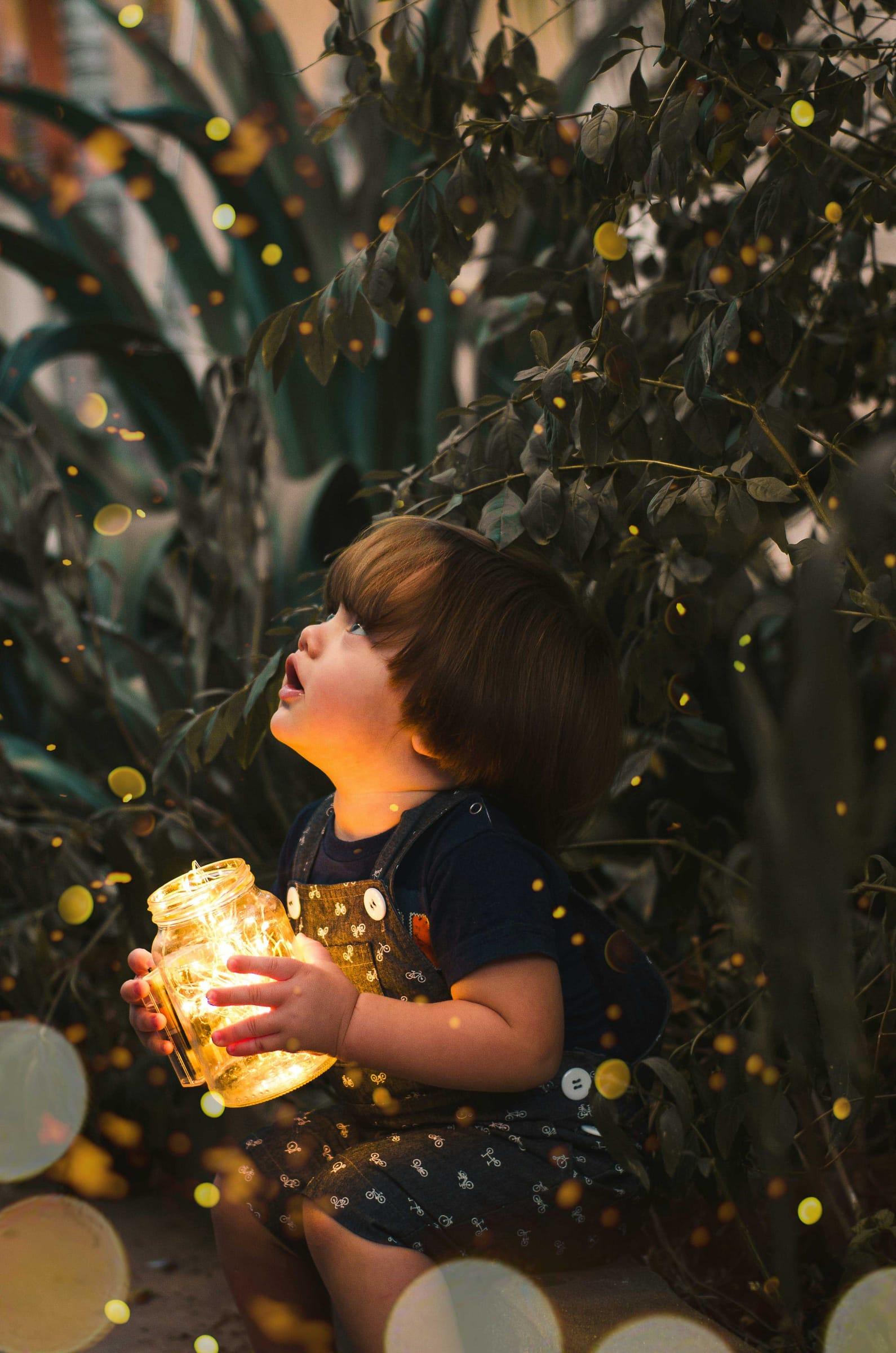 Child holding a glowing jar of lights, magical holiday mini session