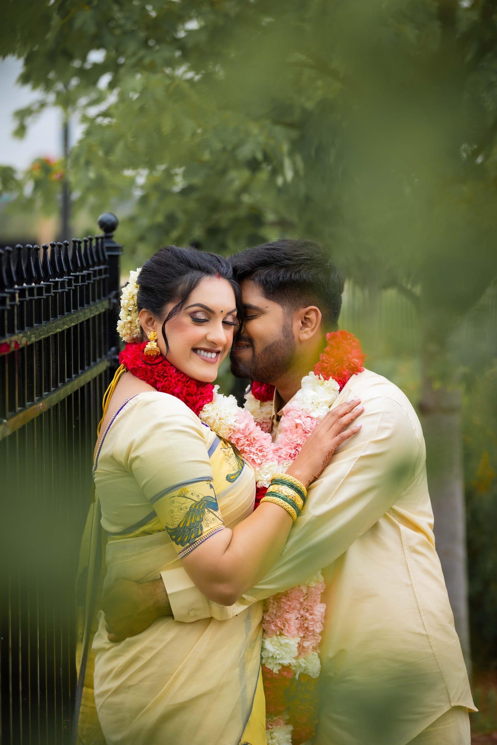 Bride and groom embrace in a garden after their South Asian wedding ceremony