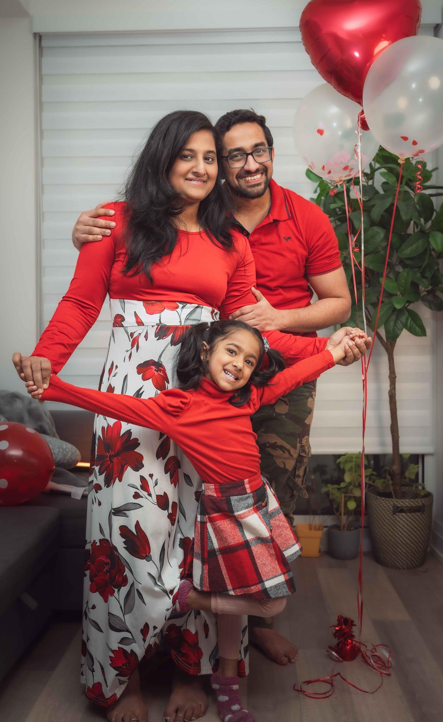 Family in festive red outfits playing at home during a holiday session