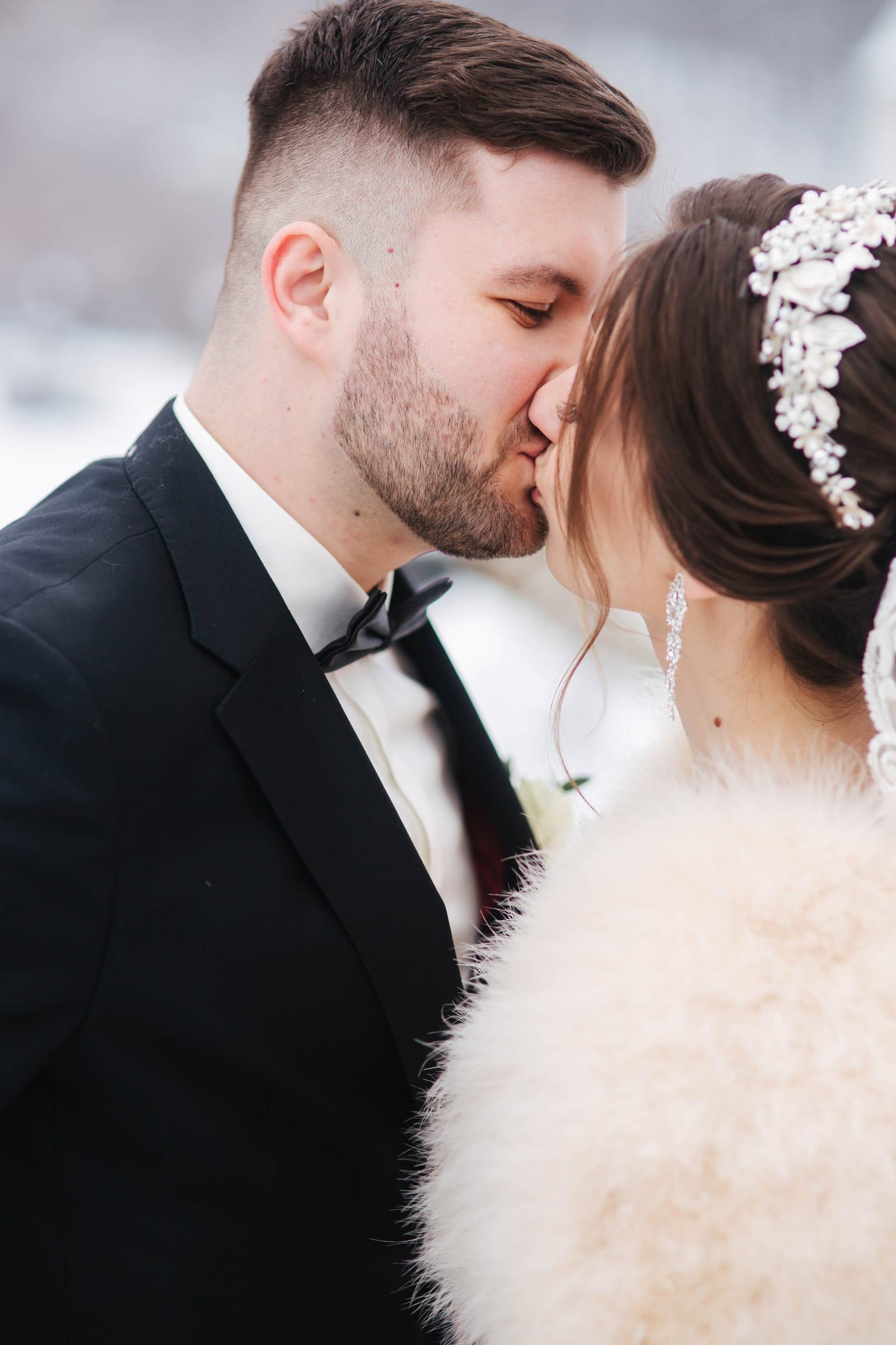 Bride and groom share a kiss in a winter wedding portrait in Toronto