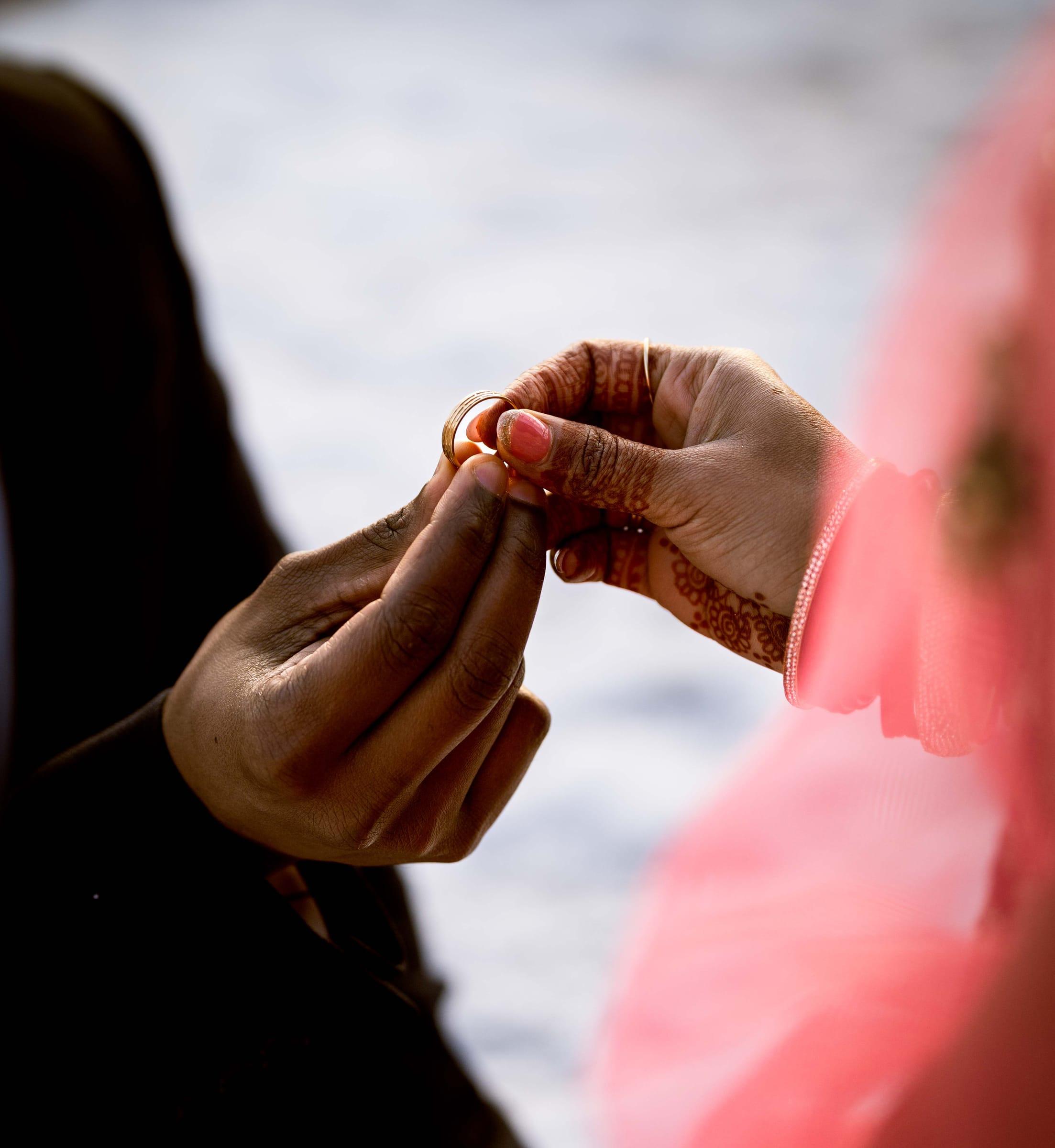 Close-up of engagement ring exchange in soft winter light