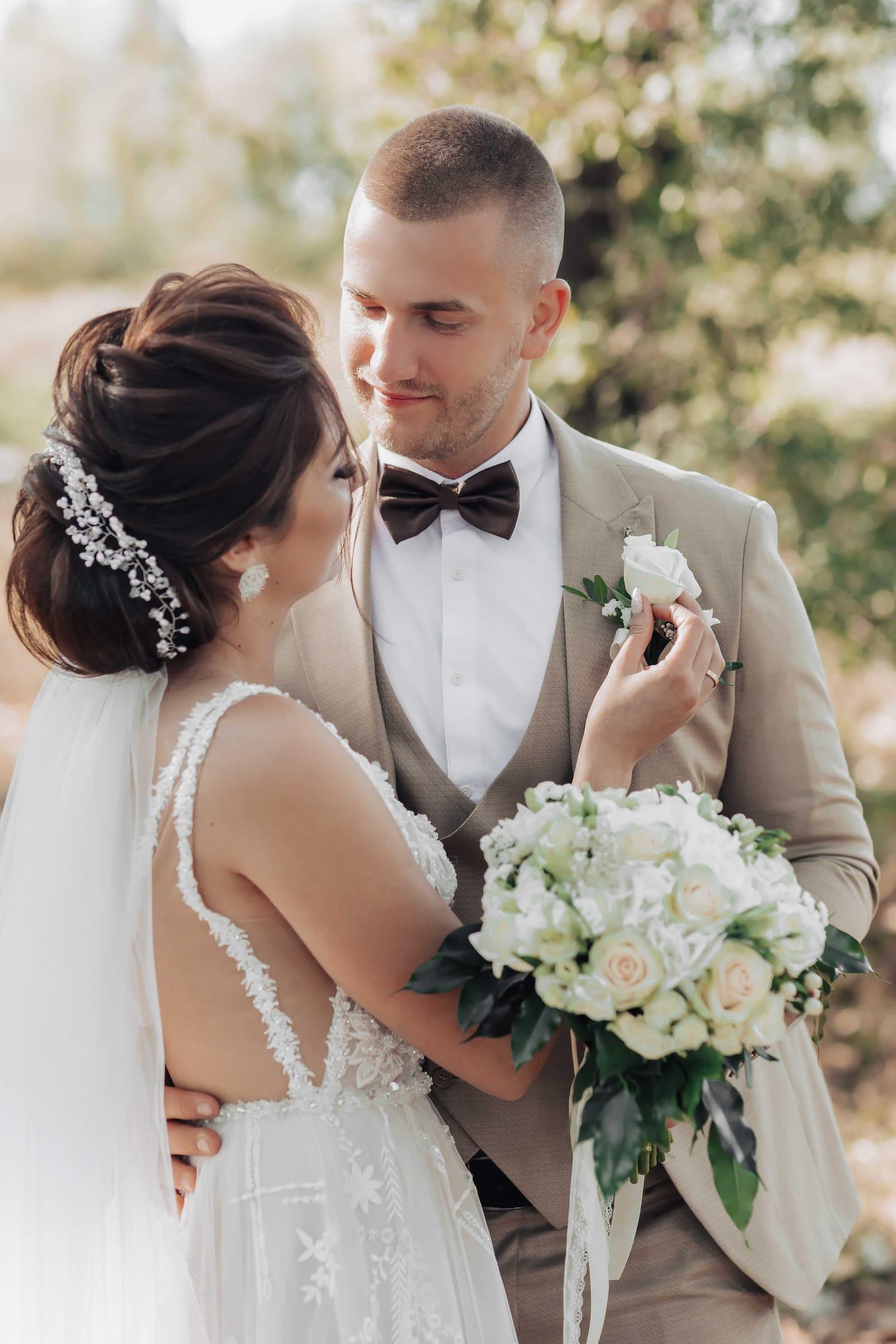 Bride and groom with white rose bouquet in a garden wedding portrait