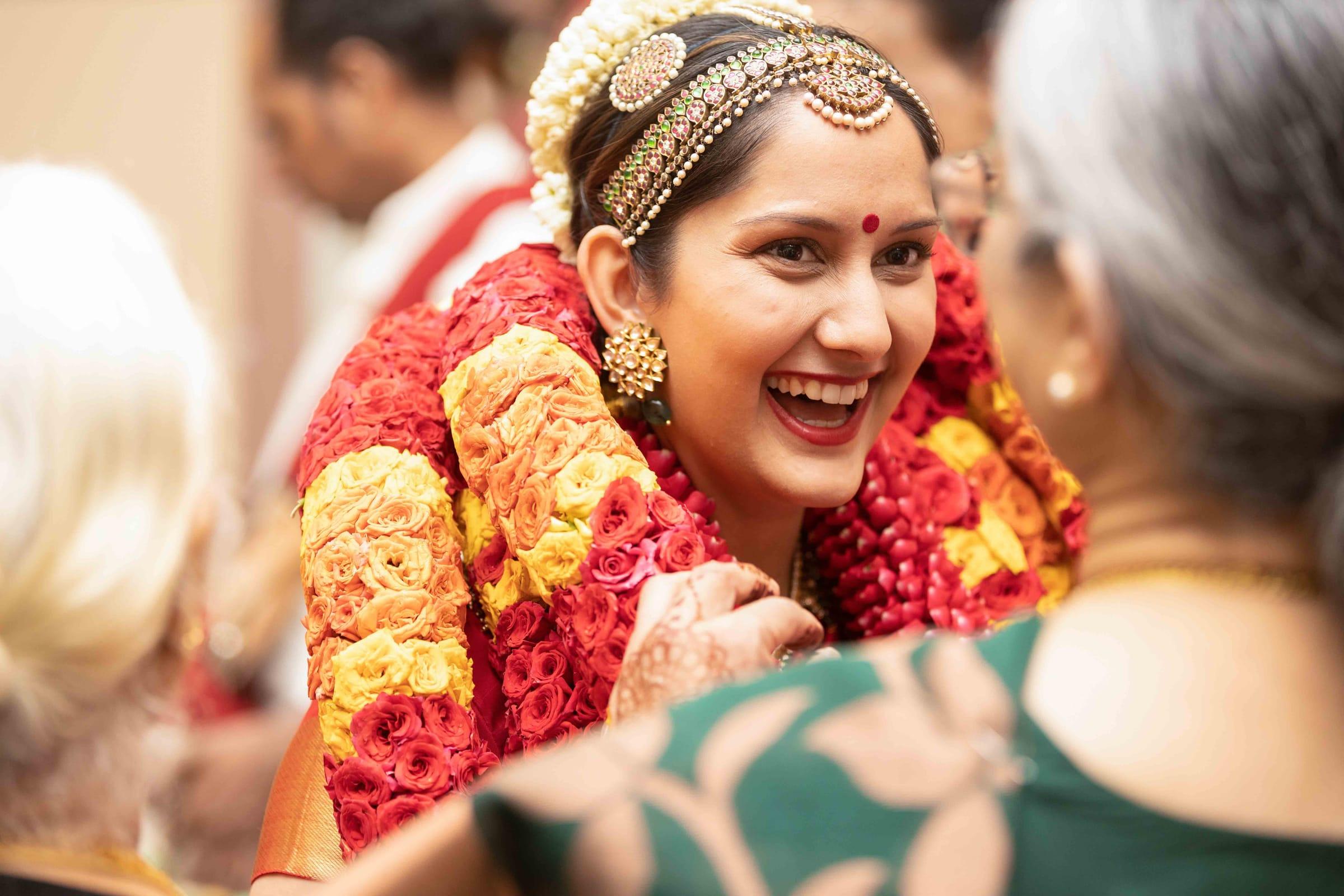 Joyful South Asian bride laughing during her wedding ceremony